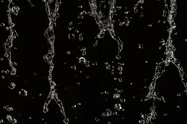 飛んで 多重ボケ水の滴を暗闇の中での水のしぶき — ストック写真