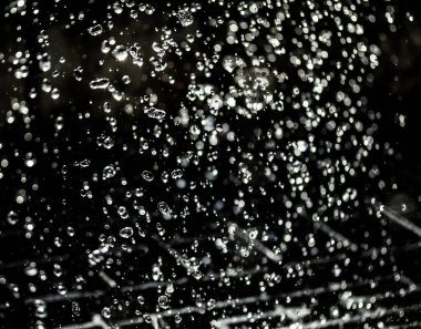 İçinde karanlık bir uçuş, ufuk bokeh su damlaları ile su sıçrama.