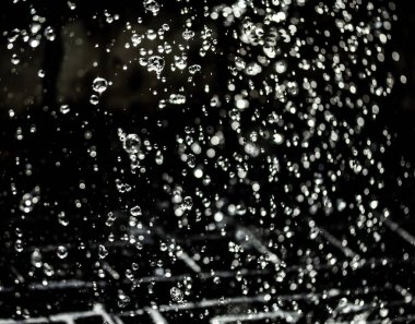 İçinde karanlık bir uçuş, ufuk bokeh su damlaları ile su sıçrama.