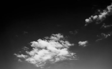 Beyaz bulutların üzerinde karanlık bir gökyüzü, tek renkli