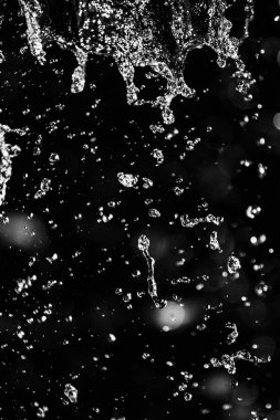 İçinde karanlık bir uçuş, ufuk bokeh su damlaları ile su sıçrama.