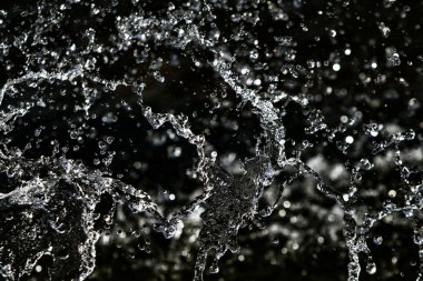 bir karanlık bokeh arka plan üstünde su damlaları