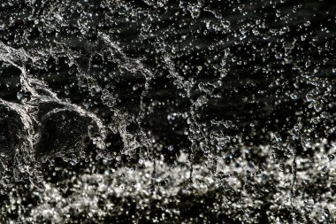 bir karanlık bokeh arka plan üstünde su damlaları