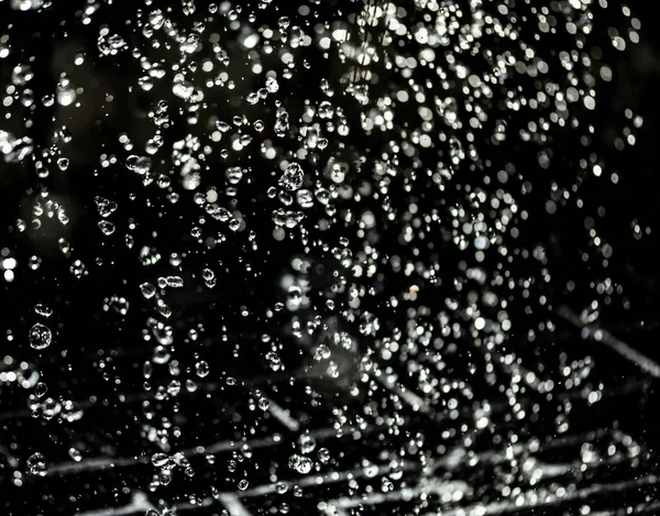 İçinde karanlık bir uçuş, ufuk bokeh su damlaları ile su sıçrama.