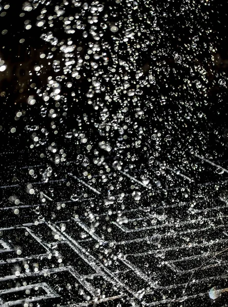 İçinde karanlık bir uçuş, ufuk bokeh su damlaları ile su sıçrama.