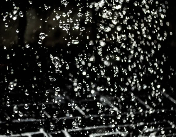 Salpicaduras Agua Oscuridad Con Gotas Agua Volando Bokeh Desenfocado —  Fotos de Stock