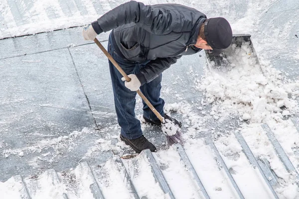 bir süpürge ile kar adam süpürür