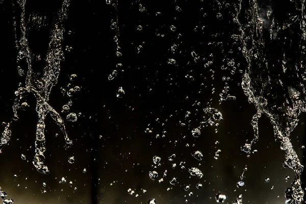 İçinde karanlık bir uçuş, ufuk bokeh su damlaları ile su sıçrama.