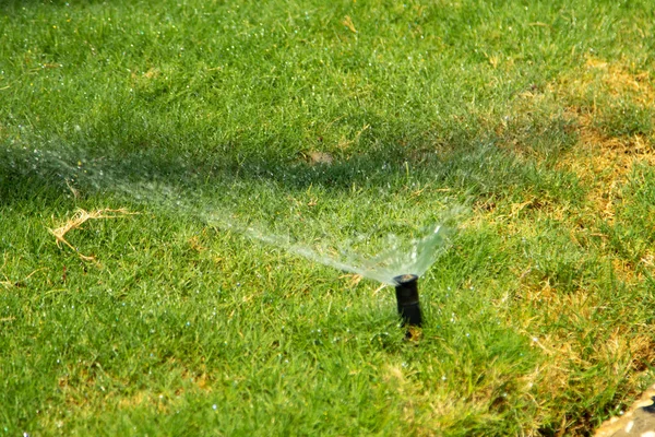 Oskärpa Bevattningssystem Vattning Det Gröna Gräset Med Bokeh Bakgrund — Stockfoto