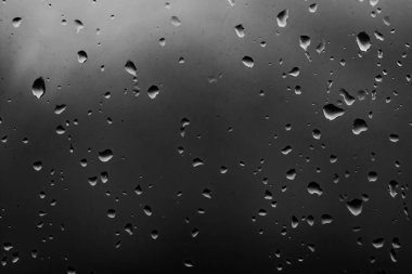 Karanlık cam arka plan üzerinde yağmur damlaları