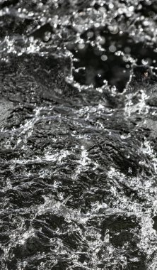 İçinde karanlık bir uçuş, ufuk bokeh su damlaları ile su sıçrama.