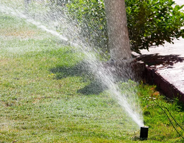 Defocused Irrigation System Watering Green Grass Bokeh Background — Stock Photo, Image