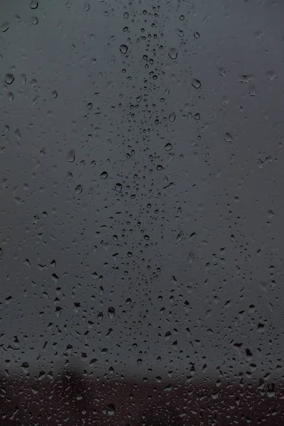 在玻璃上的雨滴 街道上的景色是模糊的 — 图库照片