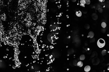 İçinde karanlık bir uçuş, ufuk bokeh su damlaları ile su sıçrama.