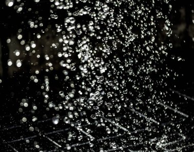 İçinde karanlık bir uçuş, ufuk bokeh su damlaları ile su sıçrama.