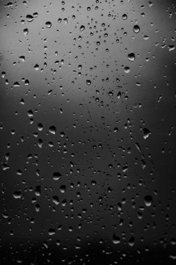Karanlık cam arka plan üzerinde yağmur damlaları