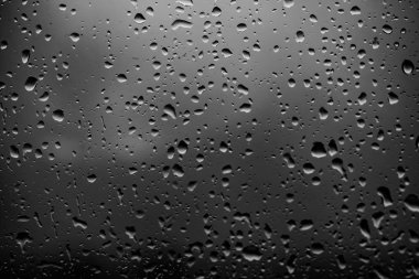 Karanlık cam arka plan üzerinde yağmur damlaları