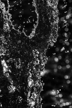 İçinde karanlık bir uçuş, ufuk bokeh su damlaları ile su sıçrama.