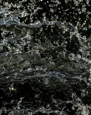 İçinde karanlık bir uçuş, ufuk bokeh su damlaları ile su sıçrama.