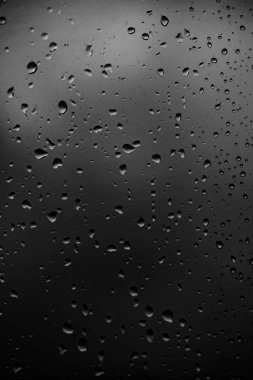 Karanlık cam arka plan üzerinde yağmur damlaları
