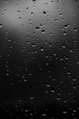 Karanlık cam arka plan üzerinde yağmur damlaları