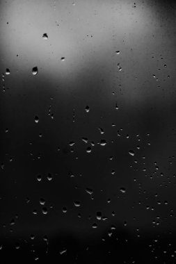 Karanlık cam arka plan üzerinde yağmur damlaları