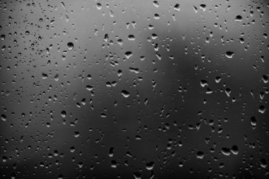 Karanlık cam arka plan üzerinde yağmur damlaları