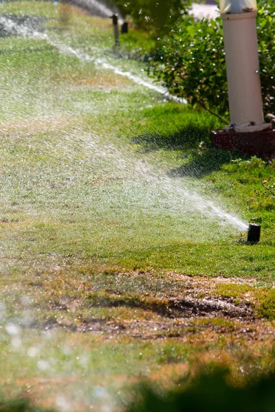 Defocused Irrigation System Watering Green Grass Bokeh Background — Stock Photo, Image