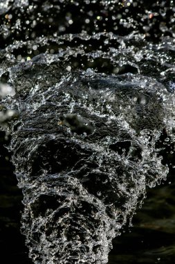 İçinde karanlık bir uçuş, ufuk bokeh su damlaları ile su sıçrama.