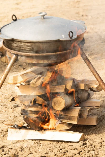 metal cauldron on fire cook on the street