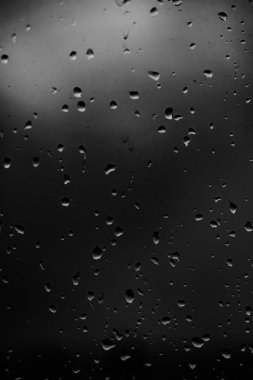 Karanlık cam arka plan üzerinde yağmur damlaları