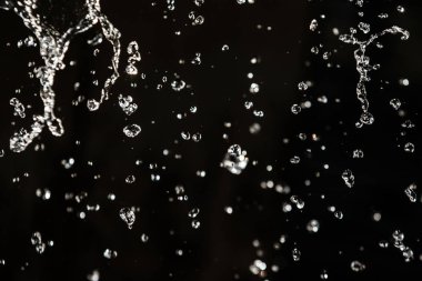 İçinde karanlık bir uçuş, ufuk bokeh su damlaları ile su sıçrama.