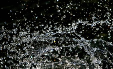 İçinde karanlık bir uçuş, ufuk bokeh su damlaları ile su sıçrama.