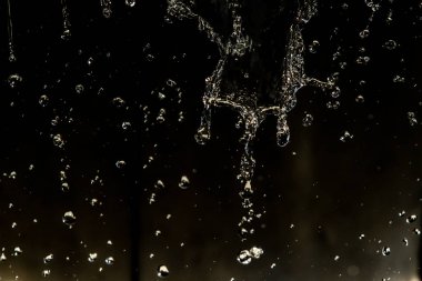 İçinde karanlık bir uçuş, ufuk bokeh su damlaları ile su sıçrama.
