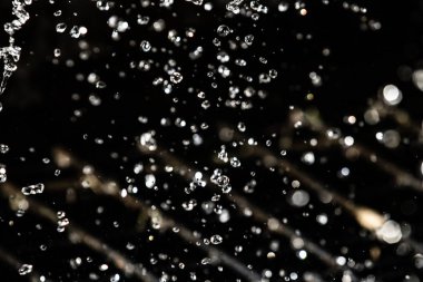 İçinde karanlık bir uçuş, ufuk bokeh su damlaları ile su sıçrama.