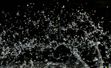 İçinde karanlık bir uçuş, ufuk bokeh su damlaları ile su sıçrama.