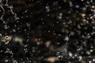 İçinde karanlık bir uçuş, ufuk bokeh su damlaları ile su sıçrama.