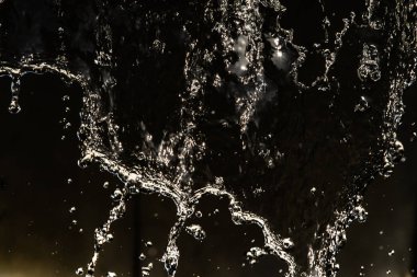 İçinde karanlık bir uçuş, ufuk bokeh su damlaları ile su sıçrama.