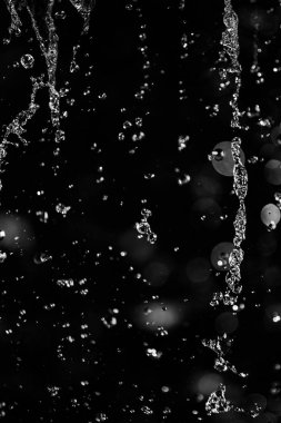 İçinde karanlık bir uçuş, ufuk bokeh su damlaları ile su sıçrama.