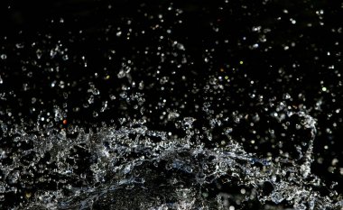 İçinde karanlık bir uçuş, ufuk bokeh su damlaları ile su sıçrama.