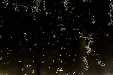 İçinde karanlık bir uçuş, ufuk bokeh su damlaları ile su sıçrama.