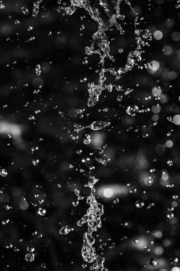 İçinde karanlık bir uçuş, ufuk bokeh su damlaları ile su sıçrama.