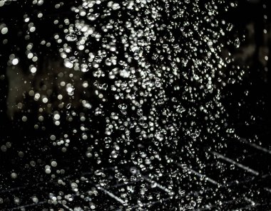 İçinde karanlık bir uçuş, ufuk bokeh su damlaları ile su sıçrama.