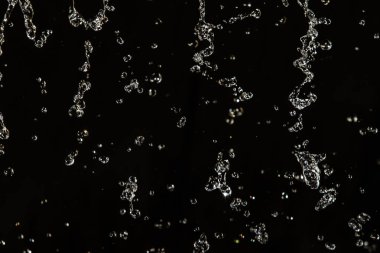 İçinde karanlık bir uçuş, ufuk bokeh su damlaları ile su sıçrama.