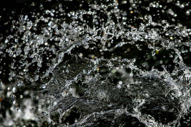 İçinde karanlık bir uçuş, ufuk bokeh su damlaları ile su sıçrama.