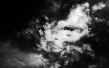 Beyaz bulutların üzerinde karanlık bir gökyüzü, tek renkli