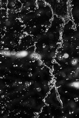 İçinde karanlık bir uçuş, ufuk bokeh su damlaları ile su sıçrama.