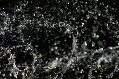 bir karanlık bokeh arka plan üstünde su damlaları