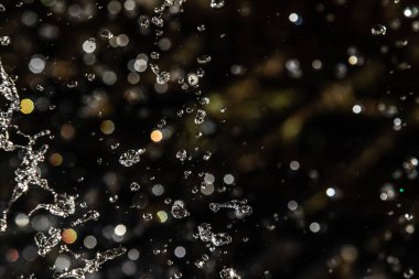 İçinde karanlık bir uçuş, ufuk bokeh su damlaları ile su sıçrama.