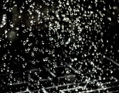 İçinde karanlık bir uçuş, ufuk bokeh su damlaları ile su sıçrama.